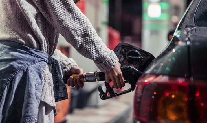 Woman's hand pumps gas into car